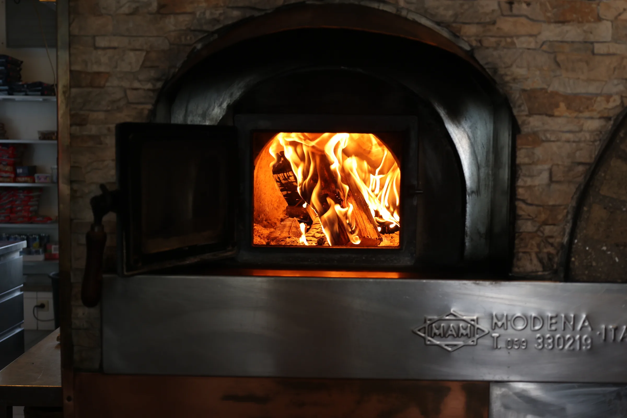 Loderndes Feuer im original Holzofen der Osteria del Mercato
